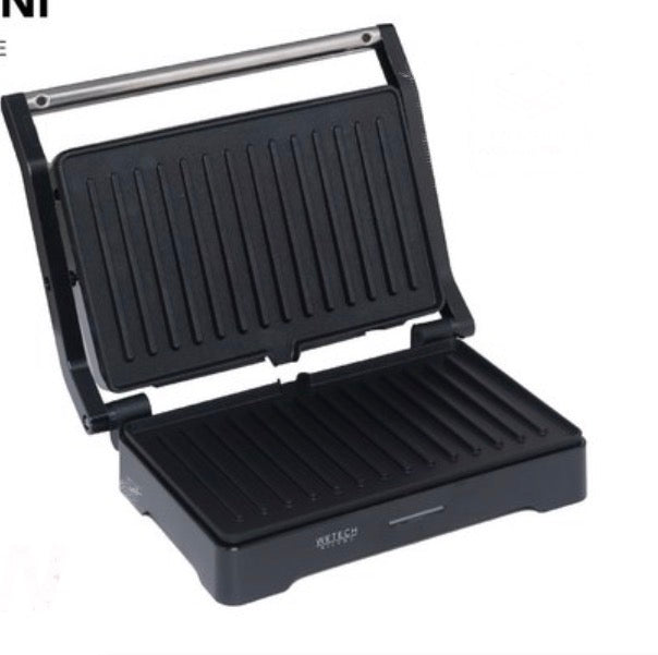 Piastra.Ha una finitura a righe su entrambe le piastre e una maniglia argentata. Sembra compatta e adatta per preparare toast, panini o grigliare piccoli alimenti.